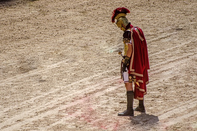 Roman gladiator looks down on bloody sand of arena floor