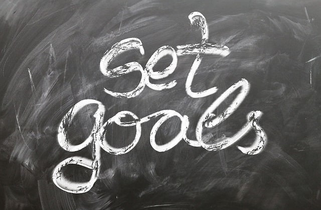 Chalkboard with words "set goals written in cursive with set written above goals