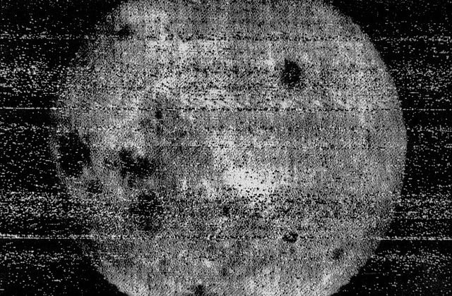 Blurry image of dark side of the moon showing prominent dark spots on the heavenly body