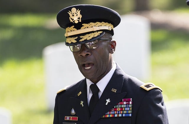 Shot from shoulders up of Maj.. Gen. Green in Army dress uniform with gravestones in the background