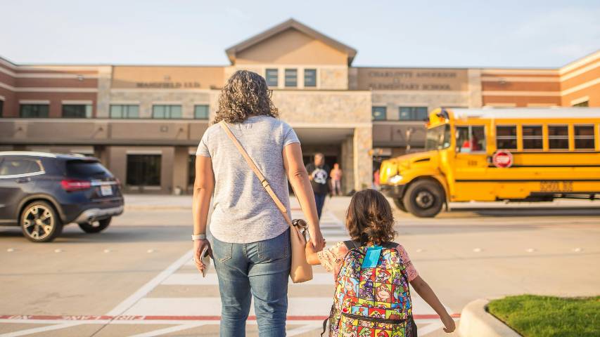 Mother walking child into school