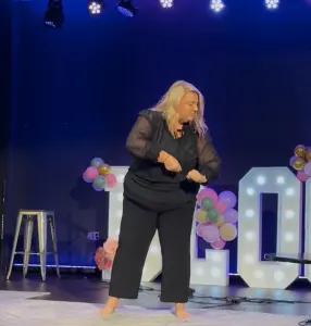 Girl doing the motions to a mime song on stage at Bloom Again KC