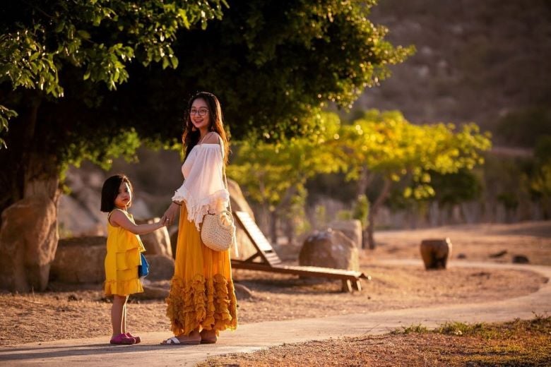 woman and child holding hands on dirt road