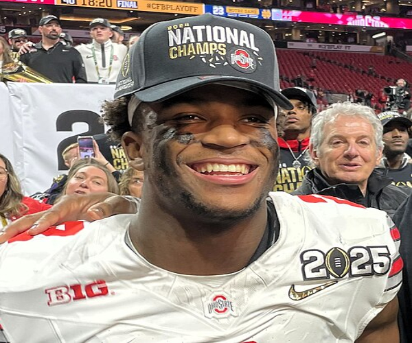 Caleb Downs, safety for the Ohio State Buckeyes, conducting a media interview on the field of Mercedes-Benz Stadium immediately after the Buckeyes won the 2025 College Football Playoff National Championship in Atlanta.