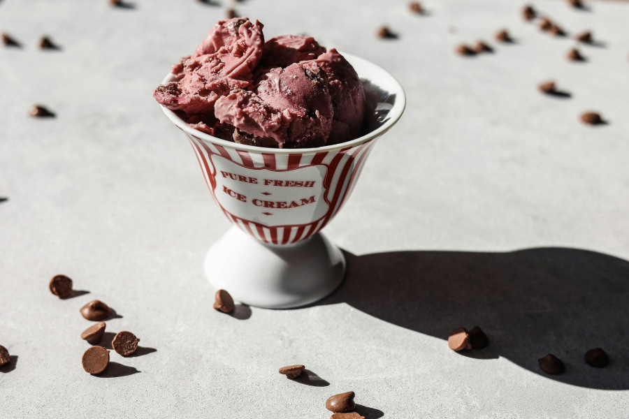 Ice cream in a fancy bowl with decorative chocolate chips in the background.