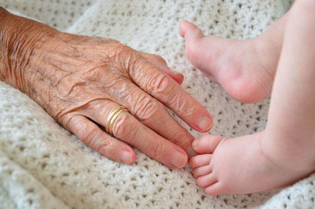 Photo of an elderly hand gently touching the toes of a baby.