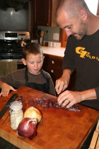 Zeke and his son preparing a venison meal.