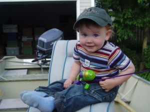 My son in boat with his first fishing pole.