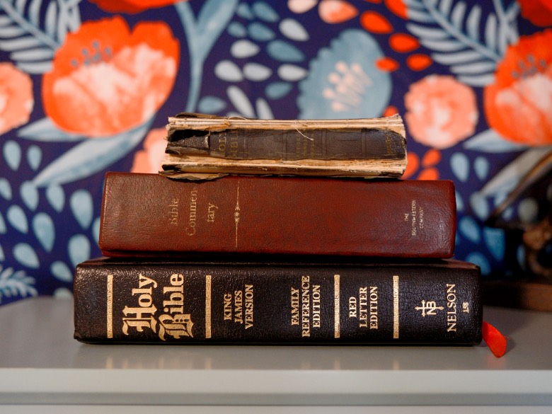 Bibles on a shelf with floral background.