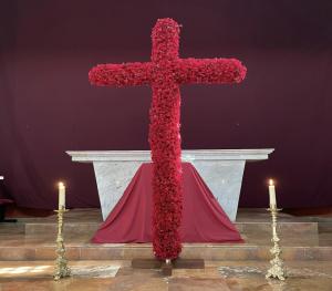 The Holy Cross covered with roses for the adoration of the faithful on Good Friday
