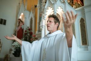 Priest extending arms and saying “Lift up your hearts”