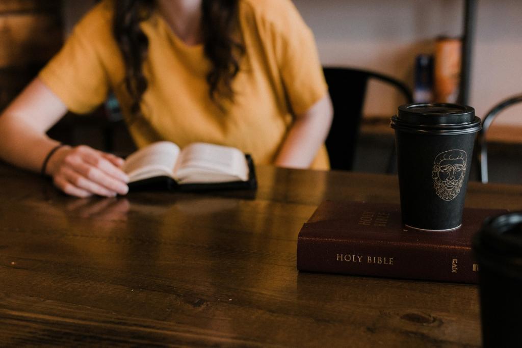 Woman with dark hair sitting at table with book open and Bible with a coffee cup. 10 Bible verses and short prayers on forgiveness.
