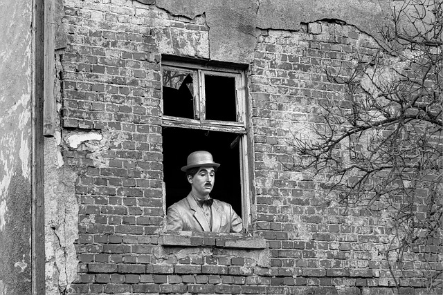 Black and White of Charlie Chaplin looking out a window.