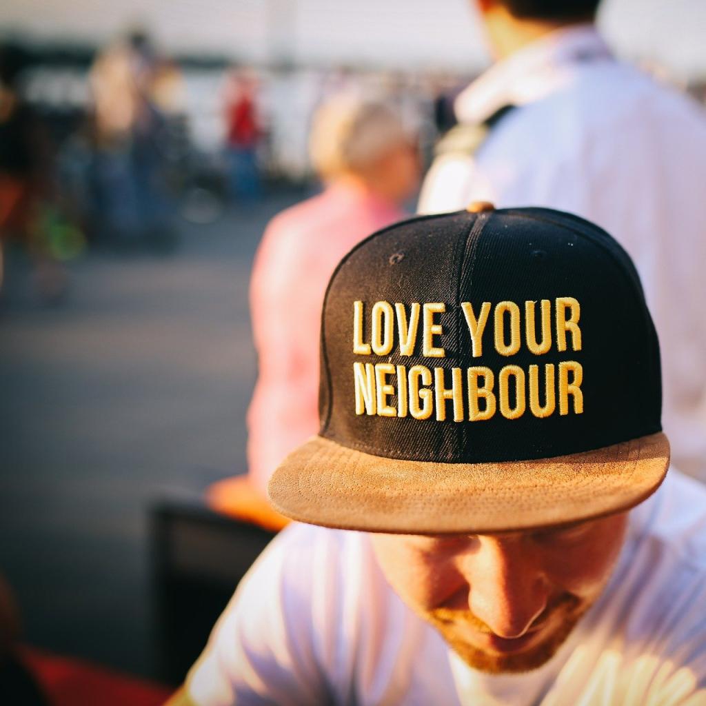 Guy wearing cap with “love your neighbor” 