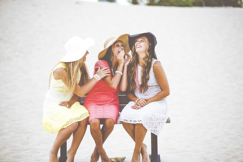 Three Girls talking and laughing together as friends.