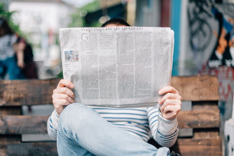 Holding a newspaper reading to know how to respond to the news