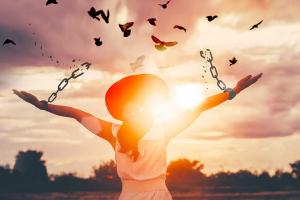 Lady's arms outstretched, breaking chains