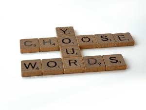 Scrabble tiles saying choose your words.