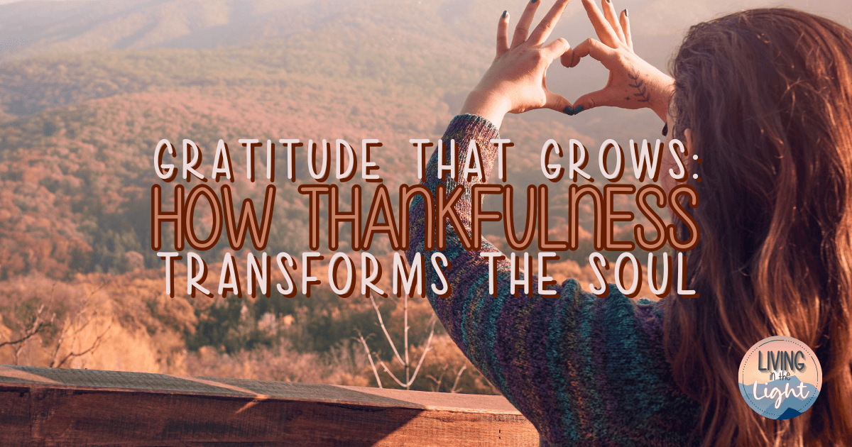 A woman stands at a mountain overlook during autumn, forming a heart shape with her hands as she looks toward the colorful fall landscape.