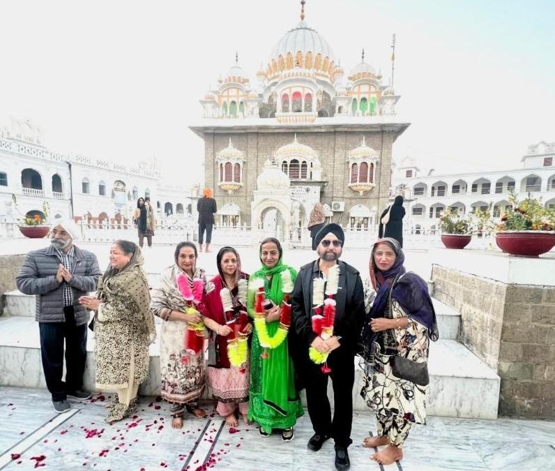 Garlanded people in front of a Sikh temple