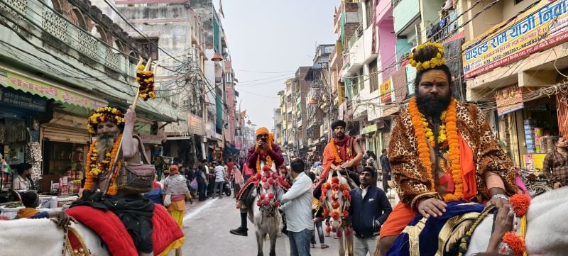 saffron-clad monks on horses in a city street