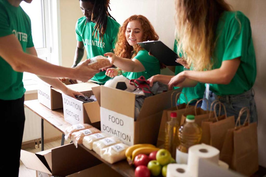 young enthusiastic volunteers with donations for poor people, cardboard box with clothes for charity. kind people help poor, cases full of clothing for poor giving, social activity concept