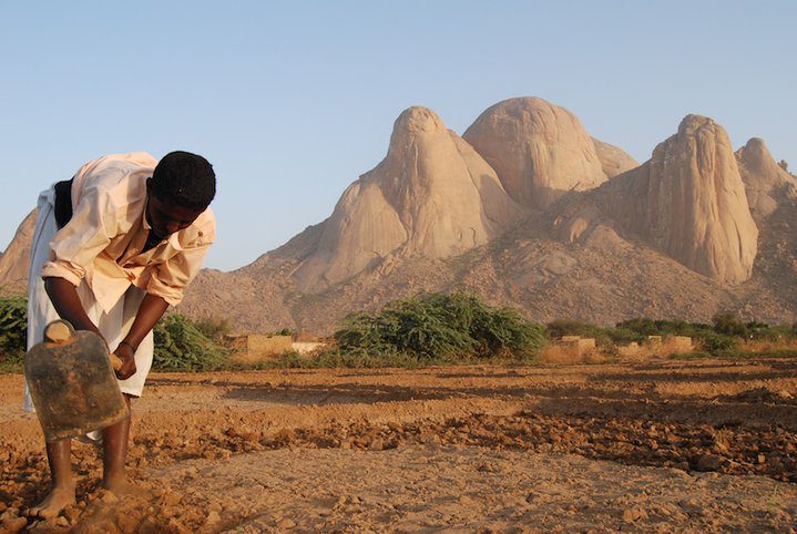 A farmer in front of Kassala's Taka Mountains. Credit: Mohamed Siddig