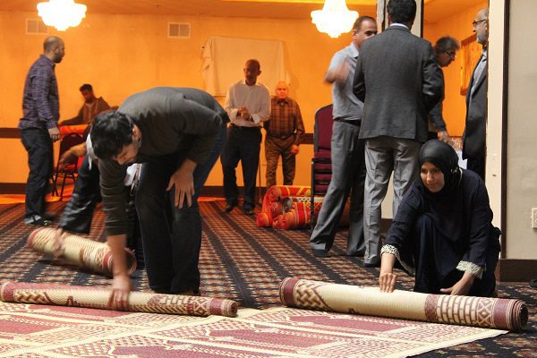 Congregants fold prayer mats after Friday prayer organized by MakeSpace. Photo: Madiha Qureshi