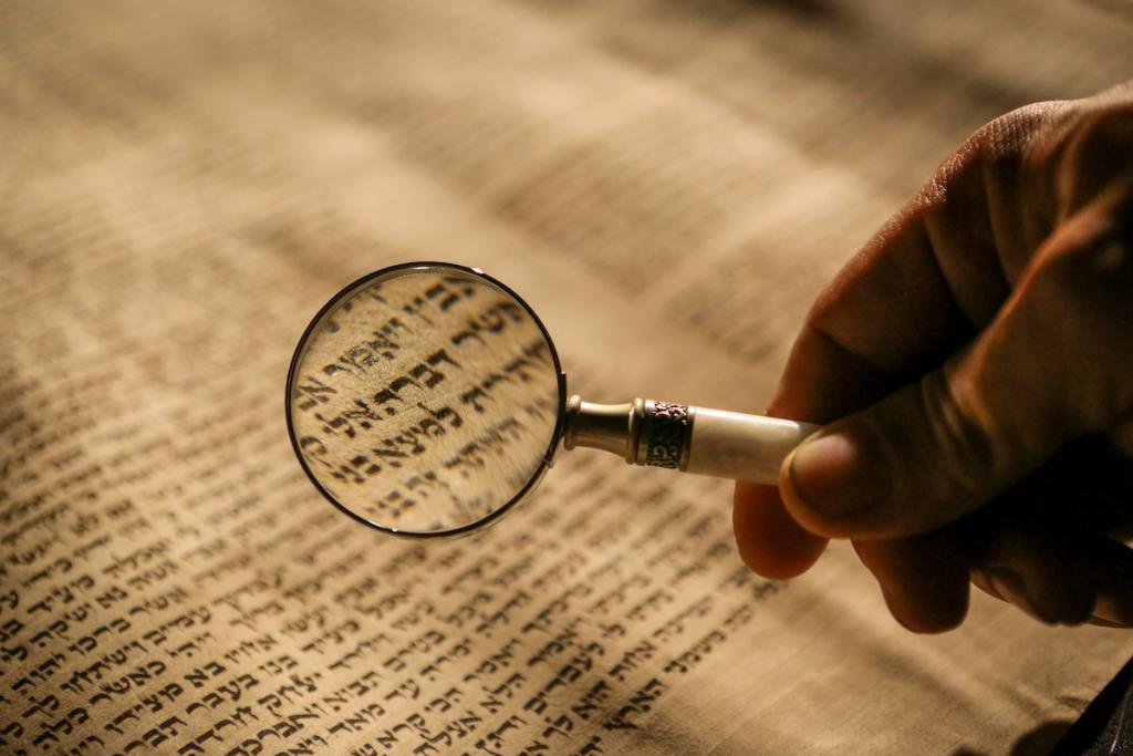 Magnifying glass over Hebrew text to symbolise investigating Biblical events