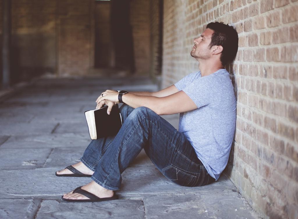 Man Praying about what he has just read in the Bible