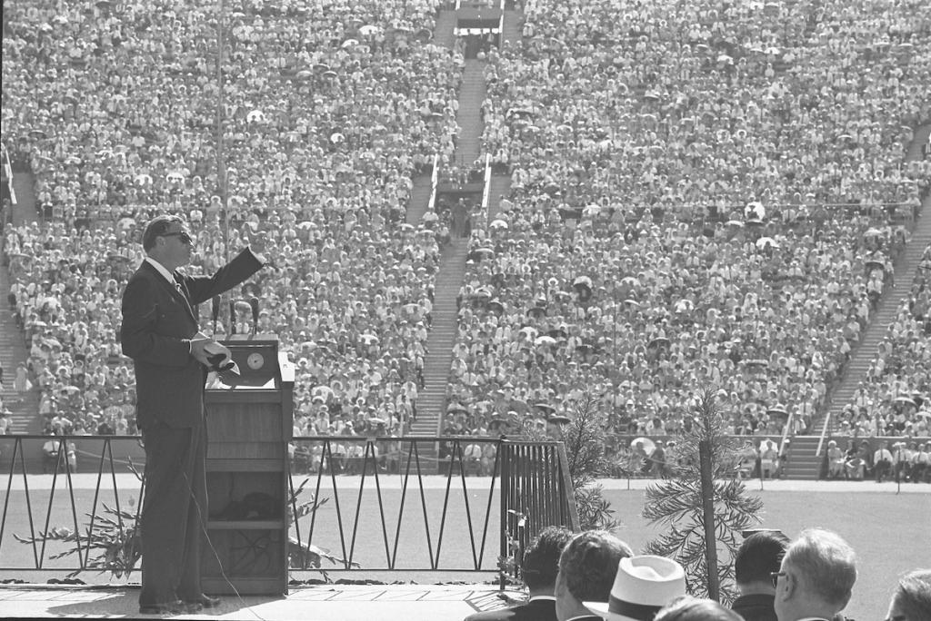 Evangelist Billy Graham speaking to crowd Los Angeles Memorial Coliseum, 1963