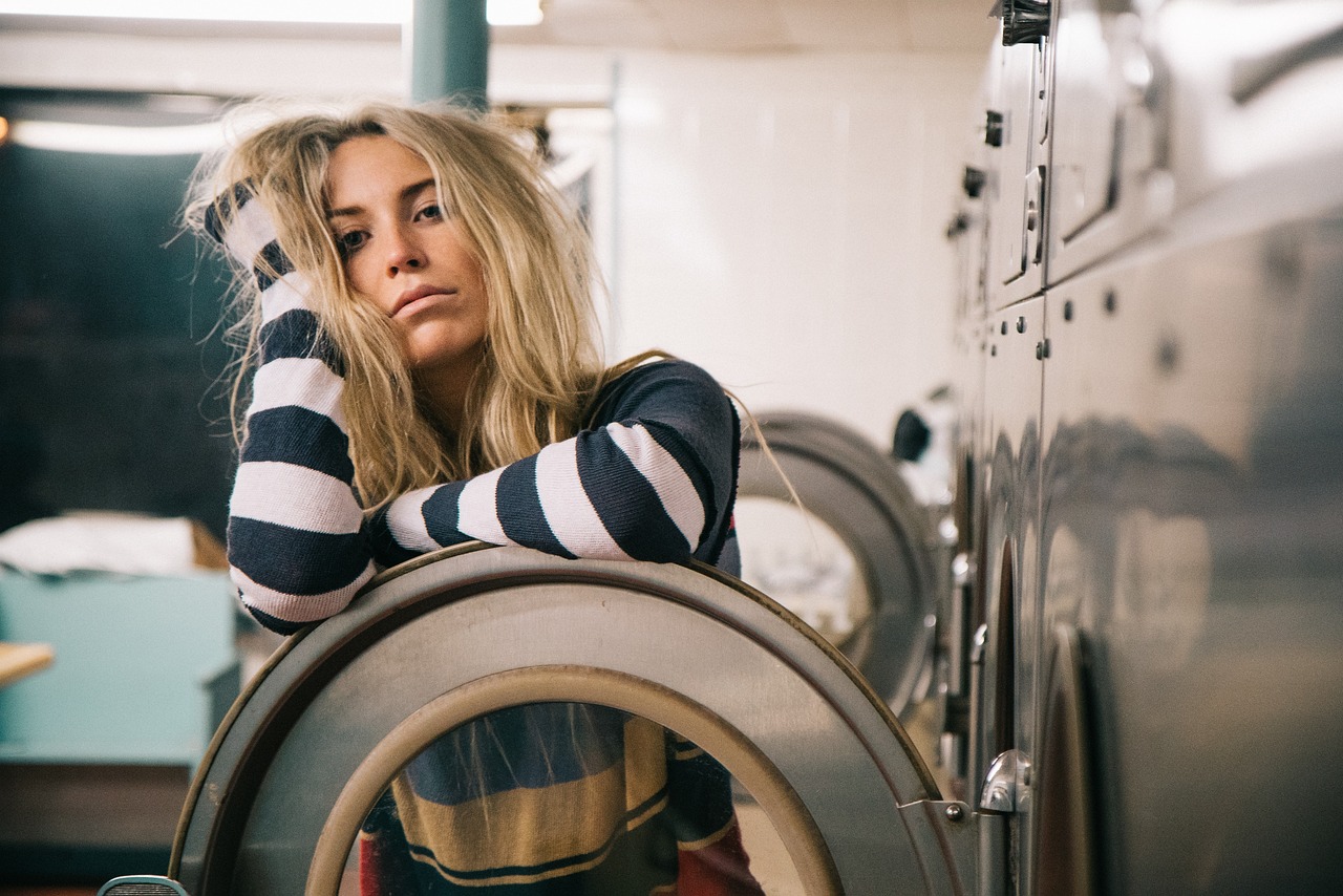 Woman in launderette clearly struggling with chronic pain and or tiredness