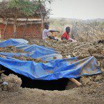 Orphans rest near foxhole, Nuba; bombings are common and frequent