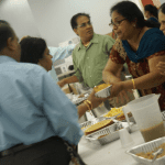  Kitchen volunteers keep trays of puri and papad flowing out to the hall. 