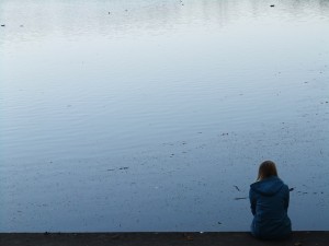 Woman on the edge of a pond, alone
