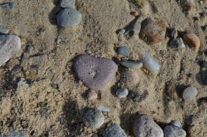 A heart-shaped stone in the sand at a beach