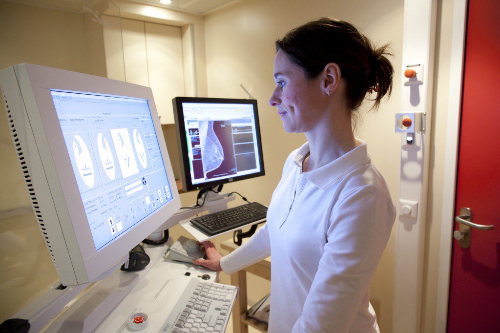 Radiology technician performing mammography scan
