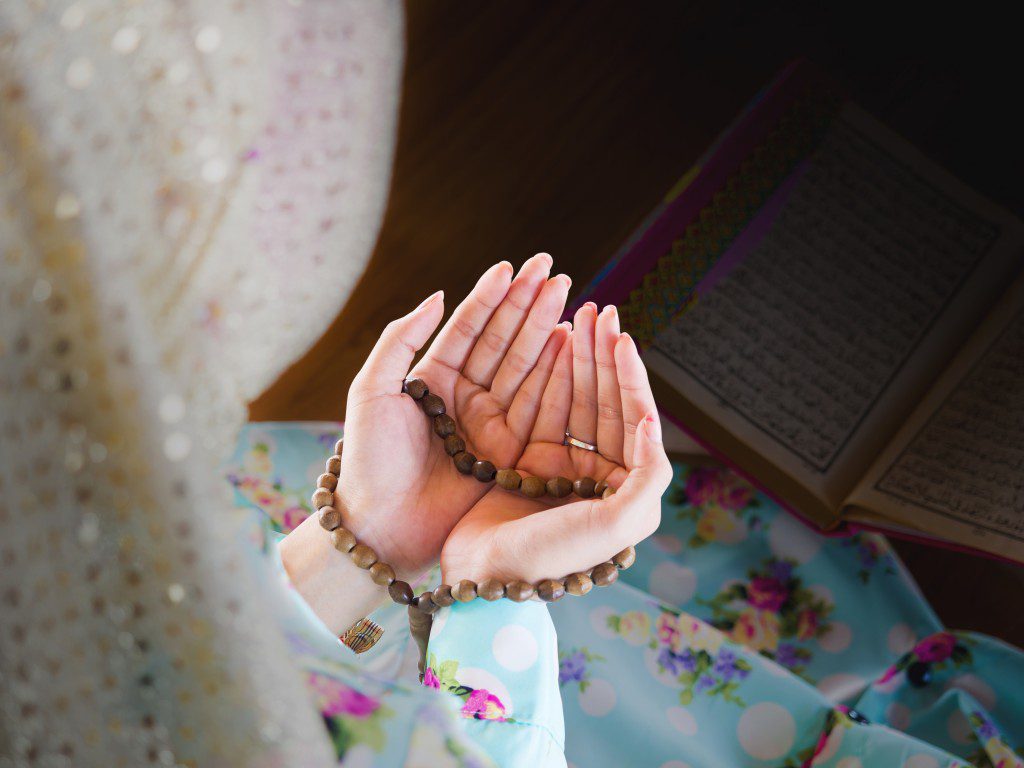 young muslim woman praying for Allah