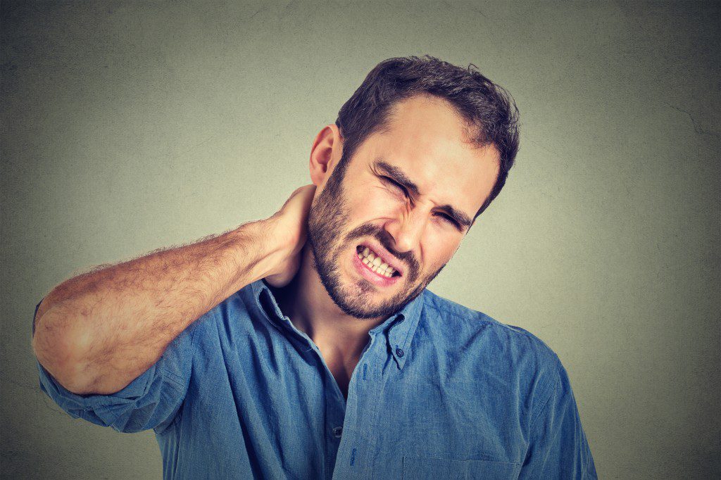 stressed, unhappy young handsome man with bad neck pain