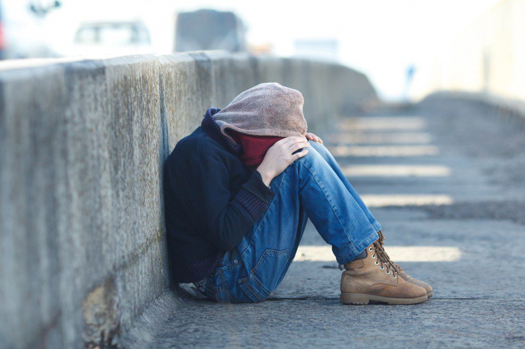 young homeless boy sleeping on the bridge