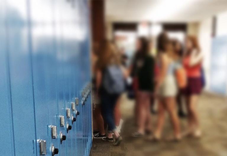 School hallway with lockers and students at the far end