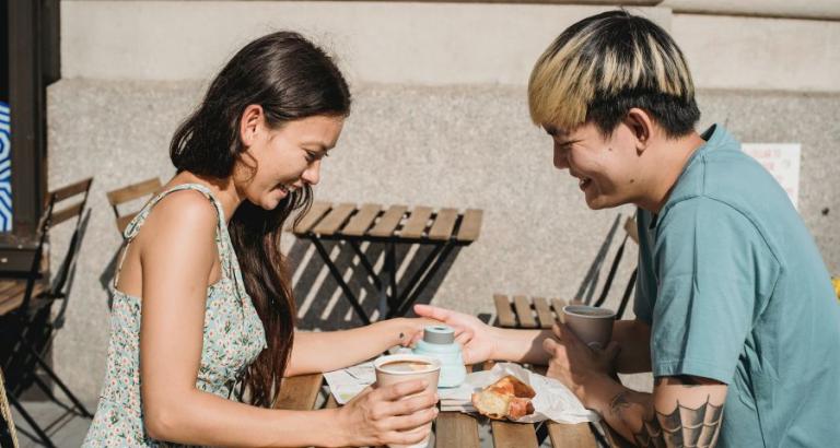 A young couple eats lunch at an outdoor cafe