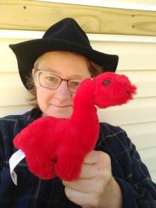 Me holding a small red plush dinosaur