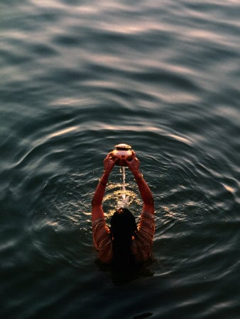 plummer-anthony-woman-pouring-water-during-morning-puja-on-ganges-varanasi-india