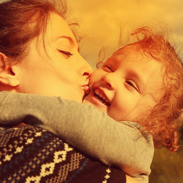 mom kissing daughter