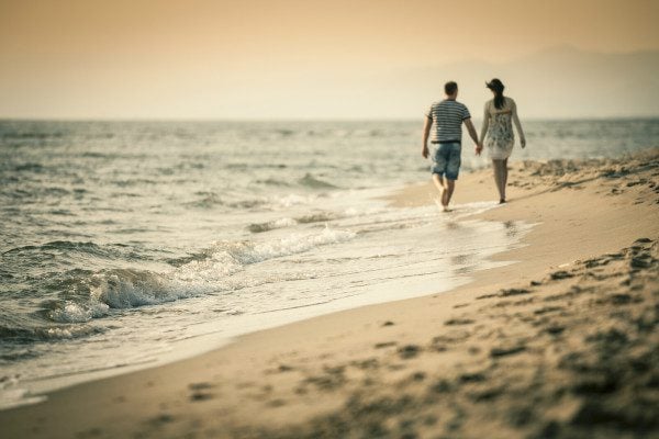 couple holding hands beach