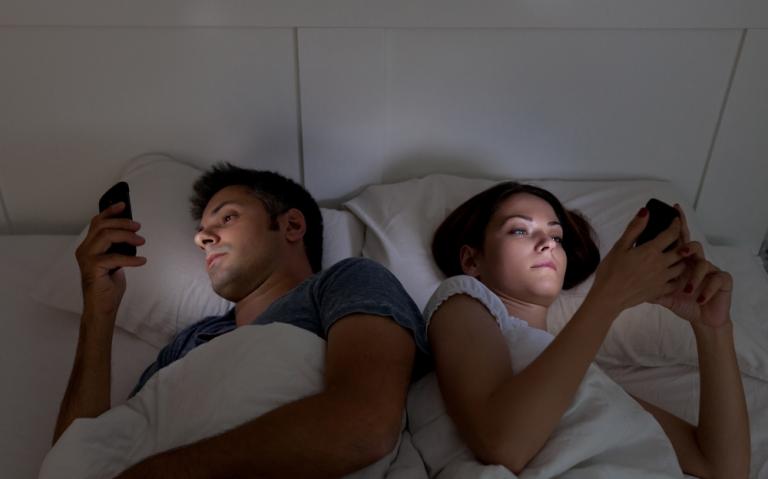 couple-in-bed-on-cell-phones