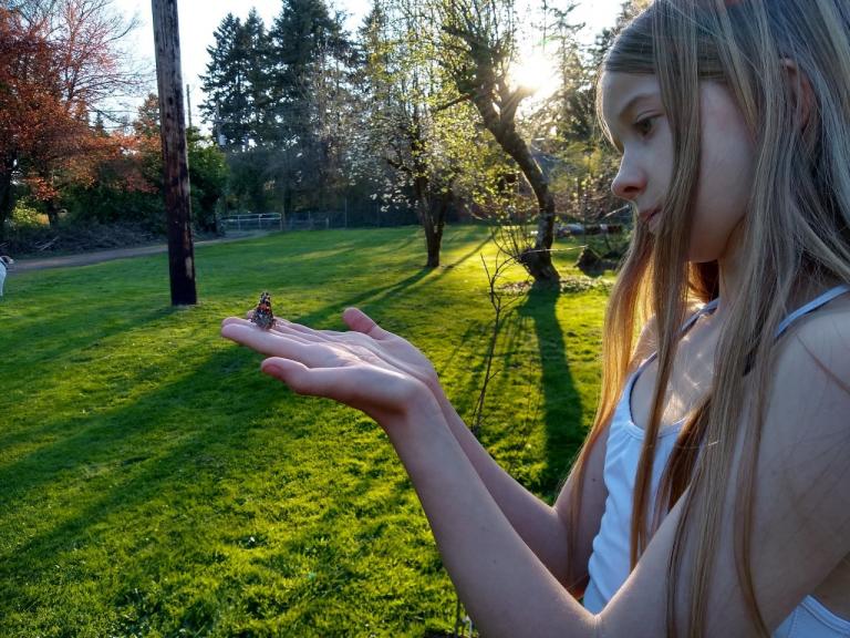 My daughter letting one of the butterflies go that the kids grew from caterpillars. The bike trail we live next to is in the background.