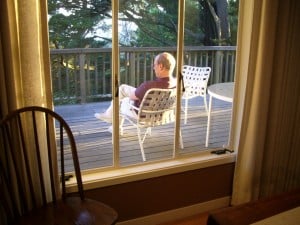 Jon Newhall reading on the deck of his house, suggesting a mood of mediation.  Photo by Barbara Newhall