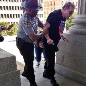 South Carolina police officer Leroy Smith, who is black, helps a white Klan supporter overcome by the heat at a July rally in support of the Confederacy in Columbia, S.C. (Photo by Rob Godfrey, a deputy chief of staff for S.C. Gov. Nikki Haley.)